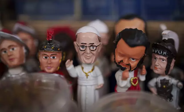 A figure of Pope Francis, center, is displayed for sale at a souvenir shop outside Santa Maria Maggiore Basilica in Rome, Tuesday, Feb. 25, 2025. (AP Photo/Bernat Armangue)