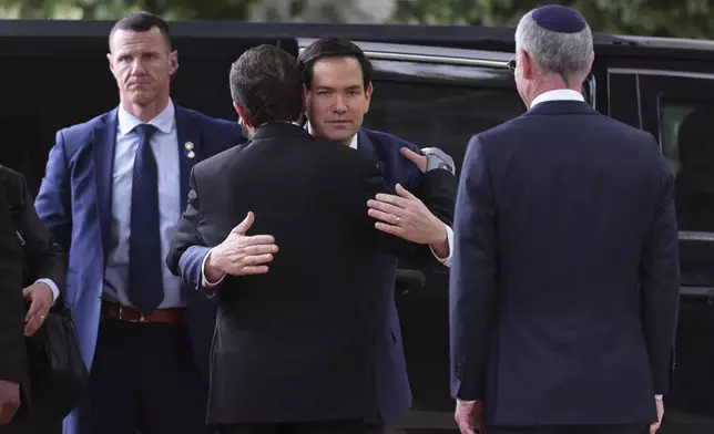 U.S. Secretary of State Marco Rubio hugs Israeli president Isaac Herzog, back to the camera, as they meet in Jerusalem, Israel, Sunday Feb. 16, 2025. (Abir Sultan/Pool Photo via AP)