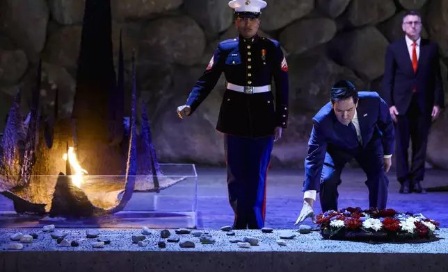 US Secretary of State Marco Rubio, front right, lays a wreath before the Eternal Flame at the Hall of Remembrance at Yad Vashem, the World Holocaust Remembrance Center, in Jerusalem, Israel, Sunday Feb. 16, 2025. (Evelyn Hockstein, Pool Photo via AP)
