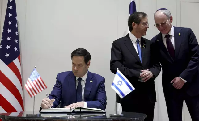 U.S. Secretary of State Marco Rubio signs the guest book during his meeting with Israeli President Isaac Herzog in Jerusalem, Israel, Sunday Feb. 16, 2025. (Evelyn Hockstein, Pool Photo via AP)