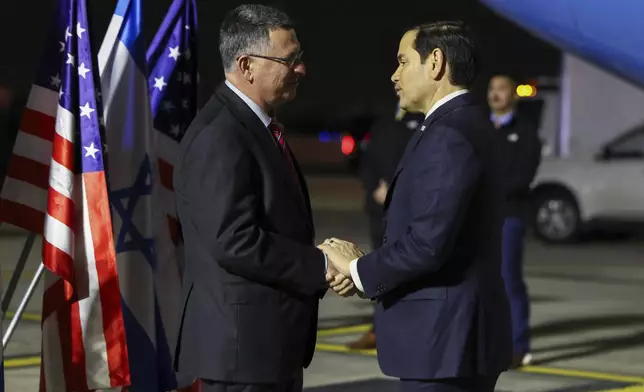 Israel's Foreign Minister Gideon Sa'ar shakes hands with U.S. Secretary of State Marco Rubio as he arrives in Israel, on the first leg of his Middle East trip, in Tel Aviv, Israel, Saturday, Feb. 15, 2025. (Evelyn Hockstein/Pool Photo via AP)