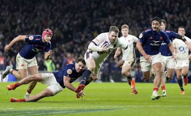 England's Elliot Daly dives to score a try despite the tackle of France's Antoine Dupont during the Six Nations match against England at Twickenham, London, Saturday Feb. 8, 2025. (Andrew Matthews/PA via AP)