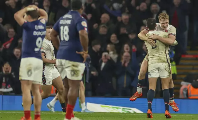 England's Fin Smith, top right, celebrates with England's Alex Mitchell after their team won the Six Nations rugby union match between England and France at Twickenham in London, Saturday, Feb. 8, 2025. (AP Photo/Ian Walton)
