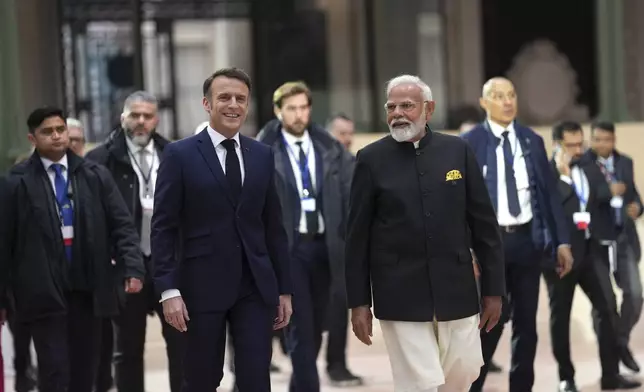 French President Emmanuel Macron, center left, walks with India's Prime Minister Narendra Modi at the Grand Palais during the Artificial Intelligence Action Summit in Paris, Tuesday, Feb. 11, 2025. (AP Photo/Aurelien Morissard)