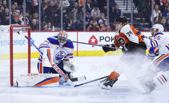 Philadelphia Flyers' Owen Tippett (74) scores a goal against Edmonton Oilers' Stuart Skinner (74) and Darnell Nurse (25) during the second period of an NHL hockey game, Saturday, Feb. 22, 2025, in Philadelphia. (AP Photo/Matt Slocum)