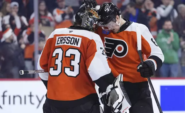 Philadelphia Flyers' Samuel Ersson, left, and Travis Sanheim celebrate after the Flyers won an NHL hockey game against the Edmonton Oilers, Saturday, Feb. 22, 2025, in Philadelphia. (AP Photo/Matt Slocum)