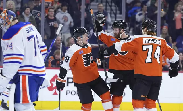 Philadelphia Flyers' Owen Tippett, from right, Sean Couturier and Matvei Michkov celebrate after a goal by Couturier against Edmonton Oilers' Stuart Skinner, left, during the second period of an NHL hockey game, Saturday, Feb. 22, 2025, in Philadelphia. (AP Photo/Matt Slocum)