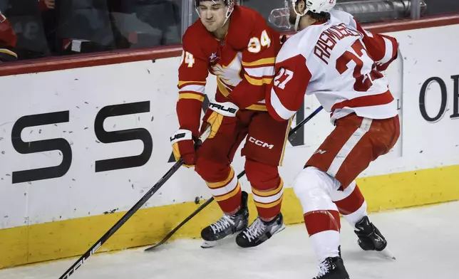 Detroit Red Wings' Michael Rasmussen, right, checks Calgary Flames' Brayden Pachal, left, during second-period NHL hockey game action in Calgary, Alberta, Saturday, Feb. 1, 2025. (Jeff McIntosh/The Canadian Press via AP)