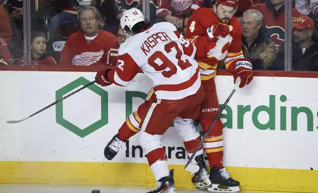 Detroit Red Wings' Marco Kasper (92) checks Calgary Flames' Rasmus Andersson during the first period of the NHL hockey game against the Calgary Flames, in Calgary, Alberta, Saturday, Feb. 1, 2025. (Jeff McIntosh/The Canadian Press via AP)