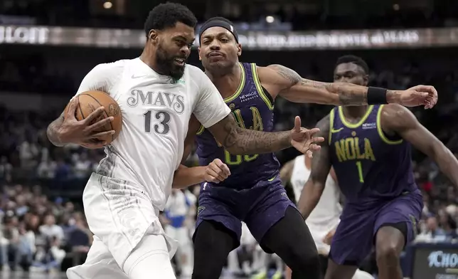 Dallas Mavericks' Naji Marshall (13) drives to the basket as New Orleans Pelicans' Bruce Brown (00) defends in the first half of an NBA basketball game in Dallas, Friday, Feb. 21, 2025. (AP Photo/Tony Gutierrez)