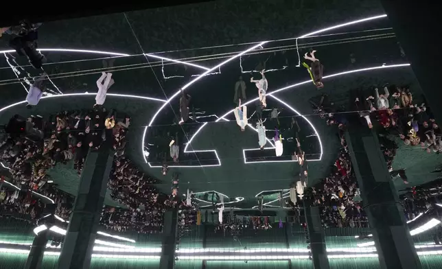 Models, reflected on the ceiling, wear creations as part of the Gucci Fall/Winter 2025-2026 men's and women's collection, presented in Milan, Italy, Tuesday, Feb. 25, 2025. (AP Photo/Luca Bruno)