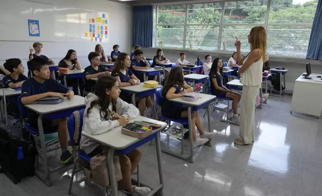 Students attend a class at Porto Seguro School on their first week at school under a new law that forbids the use of mobile phones on campus, in Sao Paulo, Thursday, Feb. 6, 2025. (AP Photo/Andre Penner)