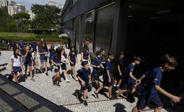 Students return to class after recess during their first week in school under a new law restricting the use mobile phones in school classrooms at Porto Seguro School in Sao Paulo, Thursday, Feb. 6, 2025. (AP Photo/Andre Penner)