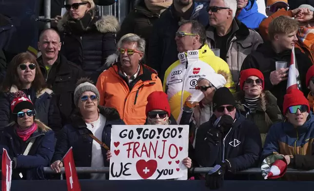 Fans hold a banner for Switzerland's Franjo von Allmen at the finish area of a men's downhill race, at the Alpine Ski World Championships, in Saalbach-Hinterglemm, Austria, Sunday, Feb. 9, 2025. (AP Photo/Giovanni Auletta)