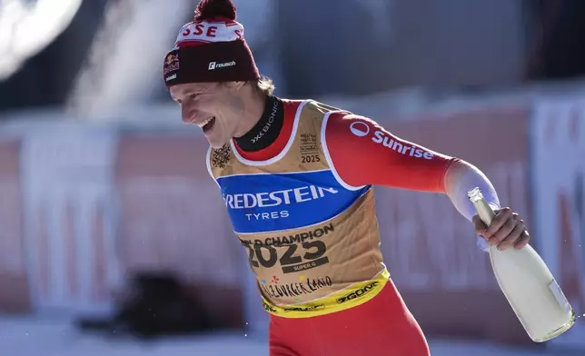 Switzerland's Marco Odermatt celebrates after winning the gold medal in a men's Super-G, at the Alpine Ski World Championships, in Saalbach-Hinterglemm, Austria, Friday, Feb. 7, 2025. (AP Photo/Giovanni Auletta)