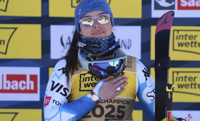 United States' Breezy Johnson listens to the national anthem after winning the gold medal in a women's downhill race, at the Alpine Ski World Championships, in Saalbach-Hinterglemm, Austria, Saturday, Feb. 8, 2025. (AP Photo/Giovanni Auletta)