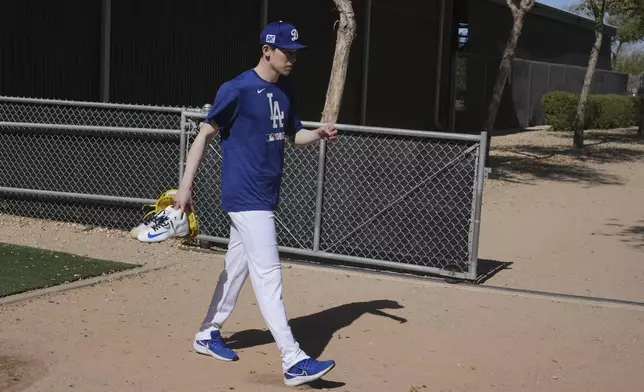 Los Angeles Dodgers pitcher Roki Sasaki, of Japan, walks to a practice field to warm up at the Dodgers baseball spring training facility, Tuesday, Feb. 11, 2025, in Phoenix. (AP Photo/Ross D. Franklin)