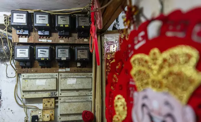 Independent electricity meters are seen on the wall outside a subdivided flat in Sham Shui Po district of Hong Kong, on Feb. 6, 2025. (AP Photo/Chan Long Hei)