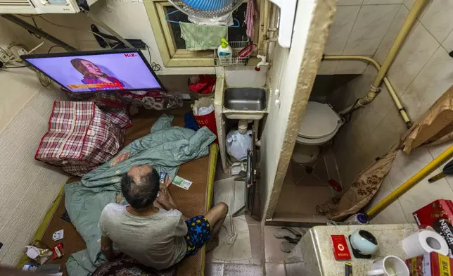 A resident who gave his name as Cheung watches television at his subdivided flat in Sham Shui Po district of Hong Kong, on Feb. 6, 2025. (AP Photo/Chan Long Hei)