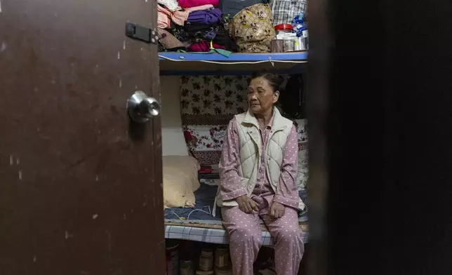 Resident Tsang Mei Qin rests at her subdivided flat in Sham Shui Po district of Hong Kong, on Feb. 6, 2025. (AP Photo/Chan Long Hei)