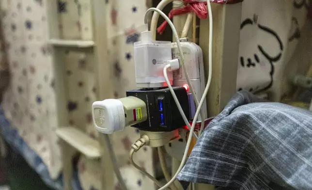 Multi-plug electric sockets are seen at a bed space in Sham Shui Po district of Hong Kong, on Feb. 6, 2025. (AP Photo/Chan Long Hei)