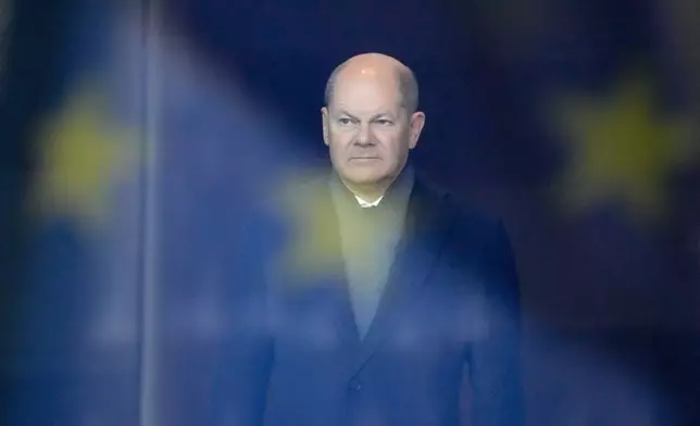 FILE - German Chancellor Olaf Scholz stands behind a reflection of the European flag in a window, as he waits for the arrival of Iraq's Prime Minister Mohamed Shia al-Sudani at the chancellery in Berlin, Germany, Jan. 13, 2023. (AP Photo/Markus Schreiber, File)