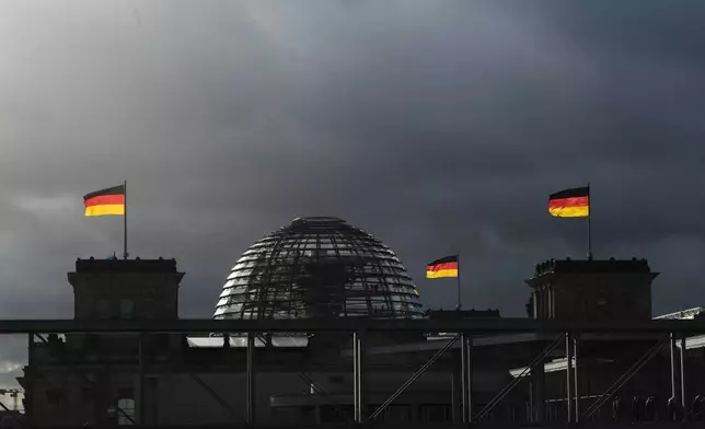 FILE - In this Friday, Nov. 29, 2019 file photo, German national flags catch the sun on top of the German parliament building, the Reichstag building in Berlin, Germany, Sunday, Sept. 26, 2021.(Photo/Markus Schreiber, File)