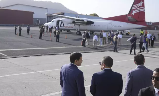 Secretary of State Marco Rubio, left, Frank Alexis Abrego, Panama's Minister of Public Security, center, and Panama's Foreign Minister Javier Martinez-Acha, watch as people board a repatriation flight bound for Colombia at Albrook Airport in Panama City, Monday, Feb. 3, 2025. (AP Photo/Mark Schiefelbein, Pool)