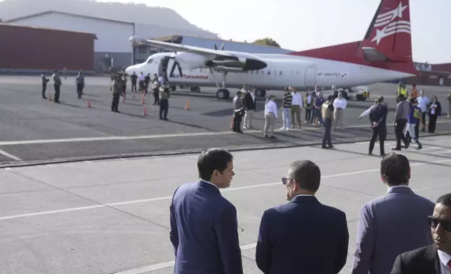 Secretary of State Marco Rubio, left, Frank Alexis Abrego, Panama's Minister of Public Security, center, and Panama's Foreign Minister Javier Martinez-Acha, watch as people board a repatriation flight bound for Colombia at Albrook Airport in Panama City, Monday, Feb. 3, 2025. (AP Photo/Mark Schiefelbein, Pool)