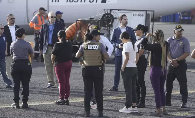 People line up to board a repatriation flight bound for Colombia at Albrook Airport in Panama City, Monday, Feb. 3, 2025. (AP Photo/Mark Schiefelbein, Pool)