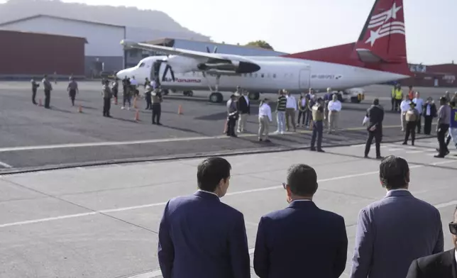 Secretary of State Marco Rubio, left, Frank Alexis Abrego, Panama's Minister of Public Security, center, and Panama's Foreign Minister Javier Martinez-Acha, watch as people board a repatriation flight bound for Colombia at Albrook Airport in Panama City, Monday, Feb. 3, 2025. (AP Photo/Mark Schiefelbein, Pool)