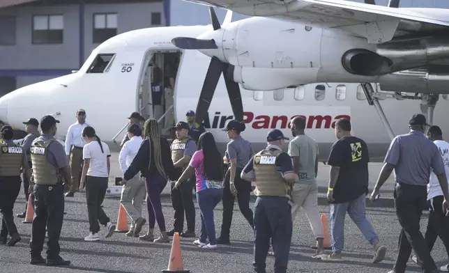 People arrive to board a repatriation flight bound for Colombia at Albrook Airport in Panama City, Monday, Feb. 3, 2025. (AP Photo/Mark Schiefelbein, Pool)
