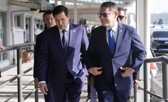 Secretary of State Marco Rubio, left, walks with Panama's Minister of Public Security Frank Alexis Abrego, after watching people board a repatriation flight bound for Colombia at Albrook Airport in Panama City, Monday, Feb. 3, 2025. (AP Photo/Mark Schiefelbein, Pool)