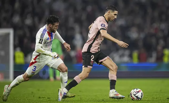 PSG's Achraf Hakimi, right, duels for the ball with Lyon's Nicolas Tagliafico during the French League One soccer match between Lyon and Paris Saint-Germain at the Groupama stadium, outside Lyon, France, Sunday, Feb. 23, 2025. (AP Photo/Laurent Cipriani)