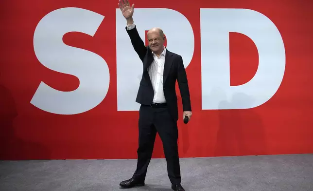 German Chancellor Olaf Scholz waves after first projections are announced during the election party at the Social Democratic Party (SPD) headquarters in Berlin, Germany, Sunday, March 23, 2025. (AP Photo/Ebrahim Noroozi)