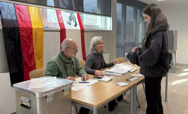 Gesa Schoenwolff, right, casts her vote at a polling station in Berlin, Germany, Sunday, Sept. 23, 2025, during the German national election. (AP Photo/Philipp-Moritz Jenne)