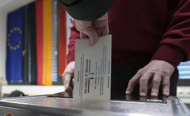 Resident casts a vote at a polling station in Berlin, Germany, Sunday, Feb. 23, 2025, during the German national election. (AP Photo/Markus Schreiber)