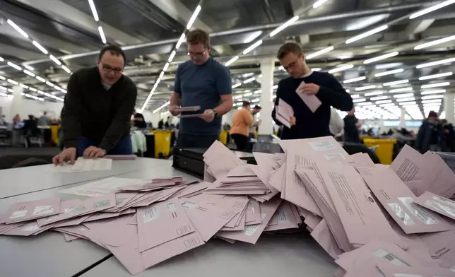 Volunteers prepare postal votes during the German national election in Munich, Germany, Sunday, Feb. 23, 2025. (AP Photo/Matthias Schrader)