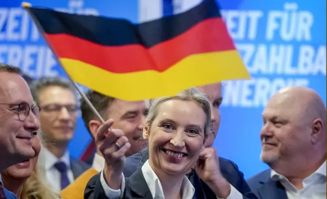 Leader of far right AfD Alice Weidel waves a German flag at the AfD party headquarters in Berlin, Germany, Sunday, Feb. 23, 2025, after the German national election. (AP Photo/Michael Probst)