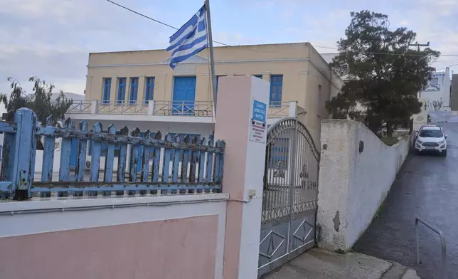 A Greek flag waves at a closed primary school due the situation as Greek authorities are taking emergency measures in response to intense seismic activity on the popular Aegean Sea holiday island of Santorini, southern Greece, Monday, Feb. 3, 2025.(AP Photo/Petros Giannakouris)