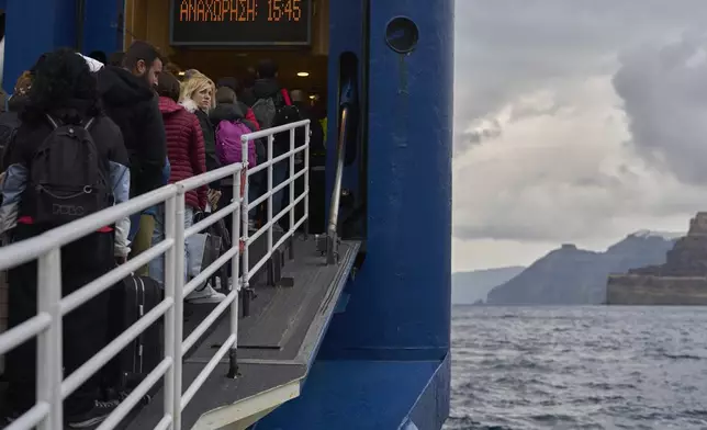 Passengers board a ferry bound for the Greek mainland, in the earthquake-struck island of Santorini, Greece, Tuesday, Feb. 4, 2025. (AP Photo/Petros Giannakouris)