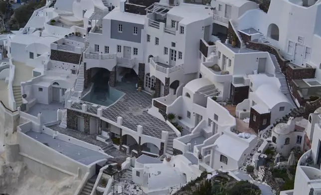An empty swimming pool is seen in a group of clifftop buildings in the town of Oia on the earthquake-struck island of Santorini, Greece, Tuesday, Feb. 4, 2025. (AP Photo/Petros Giannakouris)