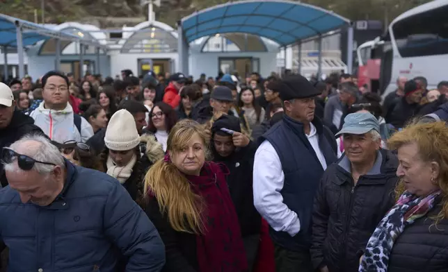 Passengers wait to board a ferry bound for the Greek mainland, in the earthquake-struck island of Santorini, Greece, Tuesday, Feb. 4, 2025. (AP Photo/Petros Giannakouris)