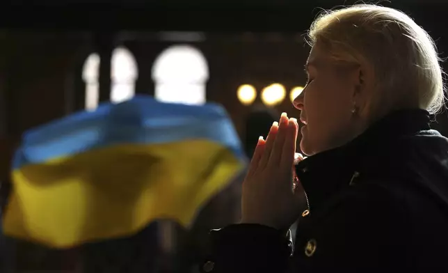 A woman attends an interfaith prayer service at the Ukrainian Catholic Cathedral to mark the third anniversary of the Russian invasion of Ukraine in London, Monday, Feb. 24, 2025. (AP Photo/Kin Cheung)