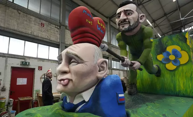A carnival float depicts Ukraine President Volodymyr Zelenskyy hitting a love hammer on Russia's President Vladimir Putin at the presentation of this year's satirical carnival floats for the Rose Monday Parade in Cologne, Germany, Tuesday, Feb. 25, 2025. (AP Photo/Martin Meissner)