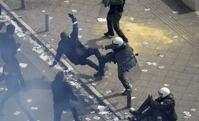 Protesters clash with Riots police outside from the parliament during a rally in central Athens, Greece to mark two years since a deadly rail disaster that has also triggered hundreds of other demonstrations and a general strike, on Friday, Feb. 28, 2025. (AP Photo/Thanassis Stavrakis)