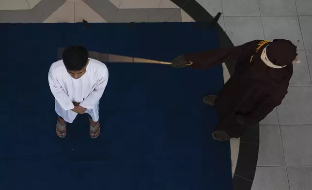 A Shariah law official uses a rattan cane to whip one of two men convicted of gay sex in Banda Aceh, Aceh province, Indonesia, Thursday, Feb. 27, 2025.(AP Photo/ Reza Saifullah)