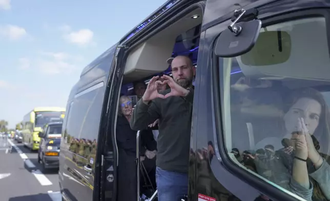 Relatives of the Bibas family show their appreciation to crowds along the road leading to the funeral of slain hostages Shiri Bibas and her two children, Ariel and Kfir, near Kibbutz Nir Oz, southern Israel, Wednesday, Feb. 26, 2025. The mother and her two children were abducted by Hamas on Oct. 7, 2023, and their remains were returned from Gaza to Israel last week as part of a ceasefire agreement with Hamas. (AP Photo/Ohad Zwigenberg)
