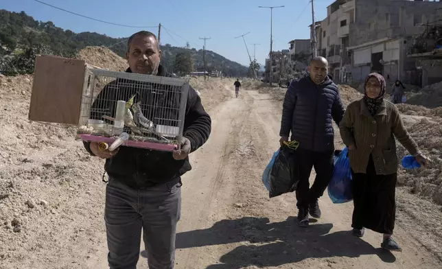 Residents of the West Bank urban refugee camp of Nur Shams evacuate their homes and carry their belongings as the Israeli military continues its operation in the area on Wednesday, Feb. 26, 2025. (AP Photo/Majdi Mohammed)