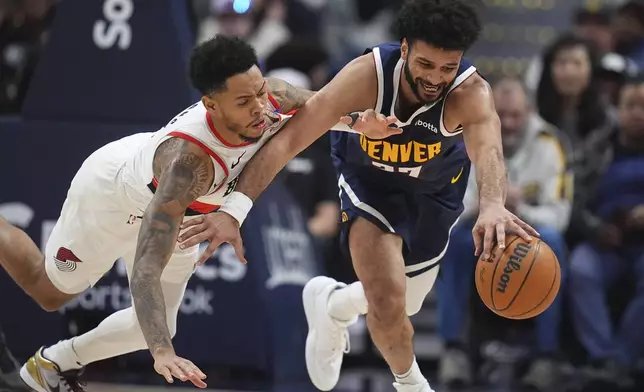 Denver Nuggets guard Jamal Murray, right, collects a loose ball as Portland Trail Blazers guard Anfernee Simons defends in the second half of an NBA basketball game Wednesday, Feb. 12, 2025, in Denver. (AP Photo/David Zalubowski)